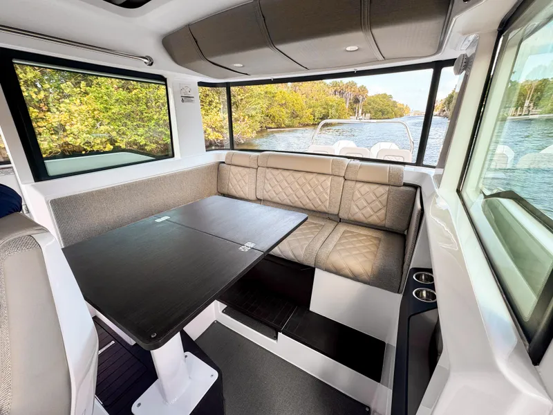 Slide: The Image of Interior of 2024 Axopar 37XC CROSS CABIN with seating and table, overlooking water. - 16