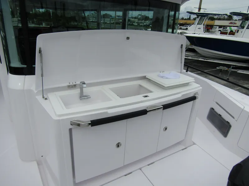 Slide: The Image of 2024 Axopar 37XC CROSS CABIN boat with outdoor sink and storage area. - 30