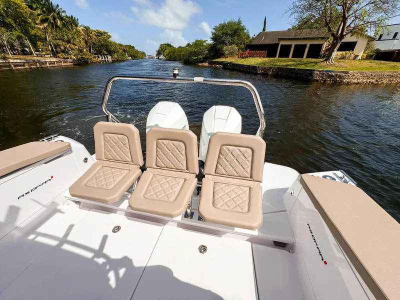 Slide: The Image of 2024 Axopar 37XC CROSS CABIN boat with rear seating on a scenic waterway. - 35