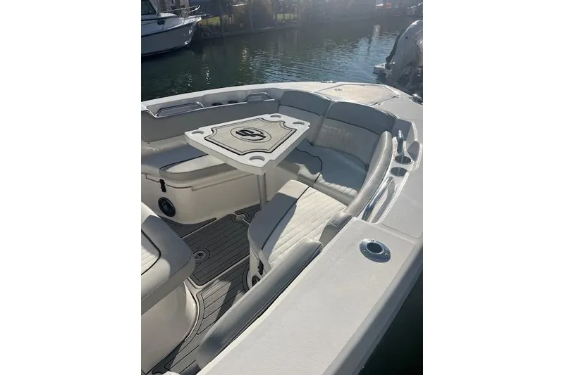 Slide: The Image of 2023 Sea Fox 228 Commander boat interior with seating and table, docked by the water. - 25