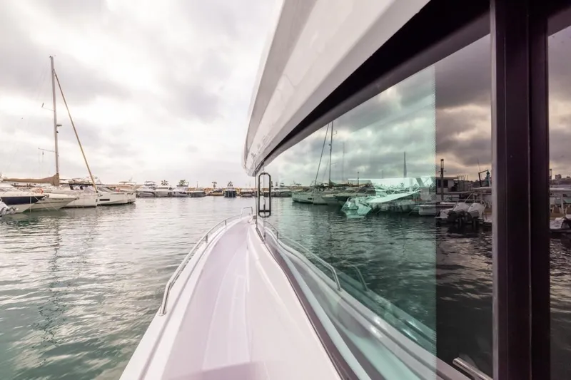 Slide: The Image of 2024 Axopar 45 XC Cross Cabin BRABUS Trim docked in a marina, reflecting on water. - 9