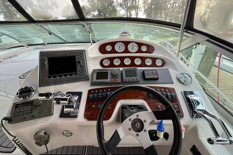 Slide: The Image of 1998 Silverton 360 Express interior with cozy seating, kitchenette, and nautical decor. - 16