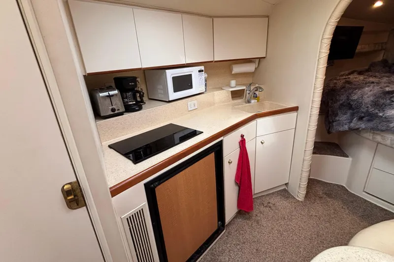 Slide: The Image of 1998 Silverton 360 Express cabin interior with curved seating, table, and carpeted stairs. - 28