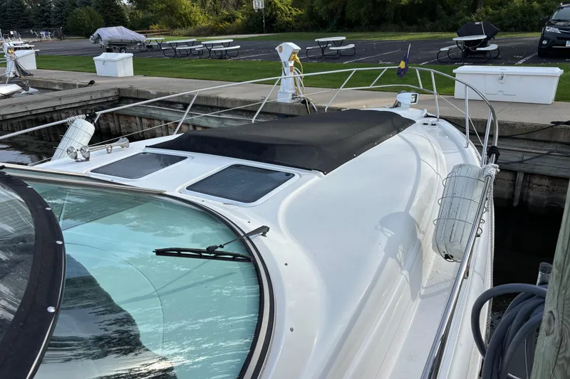 Slide: The Image of Interior of 1998 Silverton 360 Express yacht with cushioned seating and nautical-themed pillows. - 6