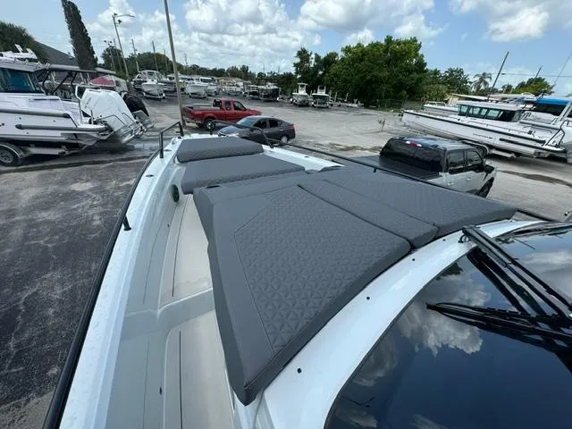 Slide: The Image of 2024 BRABUS Shadow 1000 ST boat with cushioned deck, parked in a marina. - 13