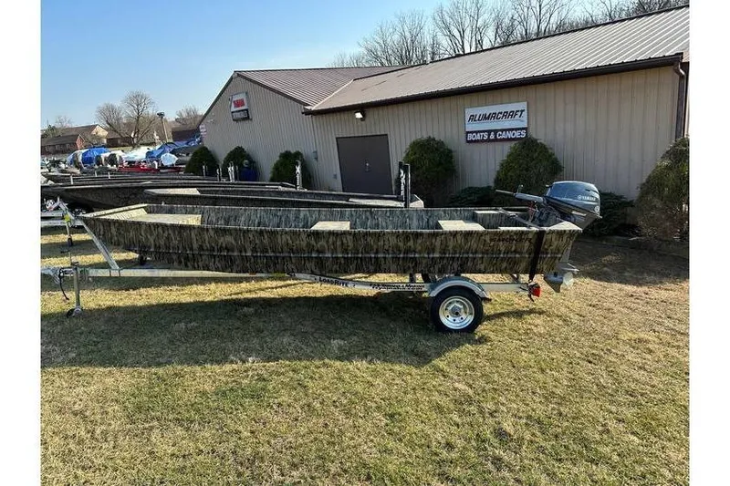 The Image of 2025 Smoker Craft Jon Boat 1448 on trailer outside Alumacraft dealership. - 1