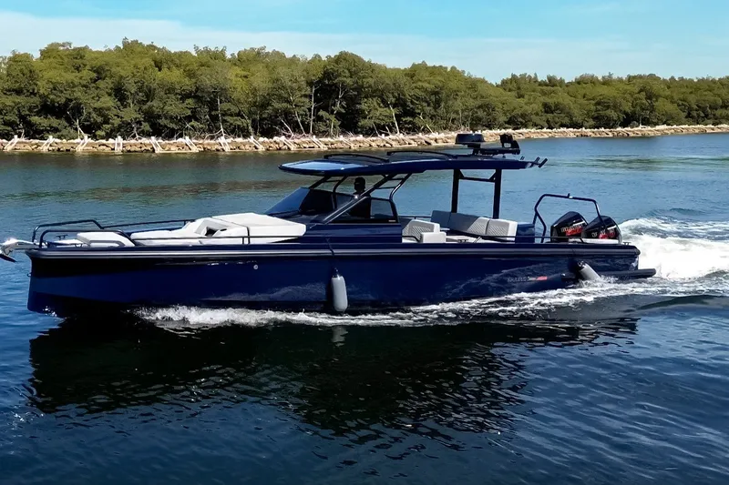 Slide: The Image of A sleek, blue motorboat cruises on calm water, surrounded by green trees. - 2