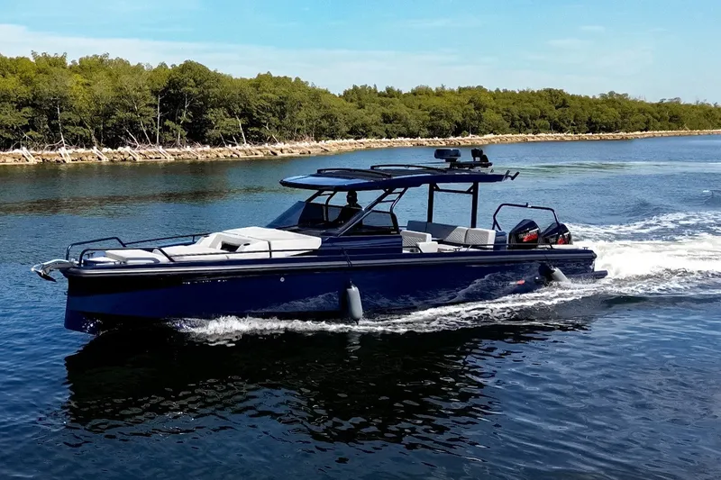 Slide: The Image of A sleek, modern boat cruising on calm waters, surrounded by trees. - 1