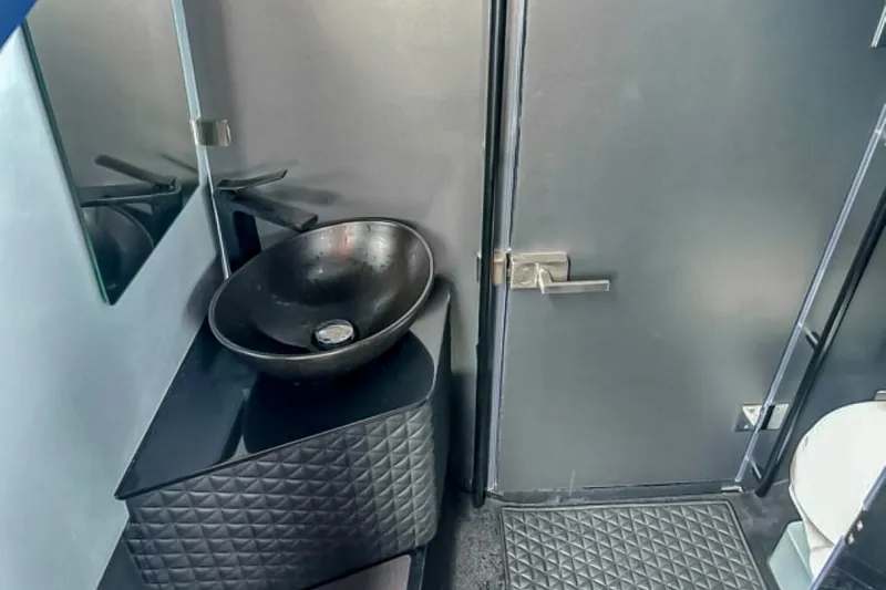 Slide: The Image of The image shows a modern bathroom with a black sink and textured cabinet front. - 46