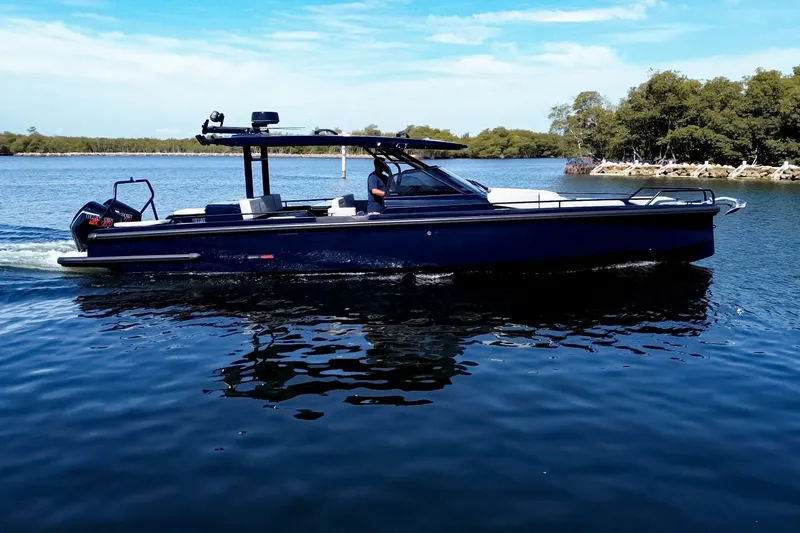 Slide: The Image of A sleek, modern motorboat cruising on calm water, surrounded by trees and blue sky. - 4