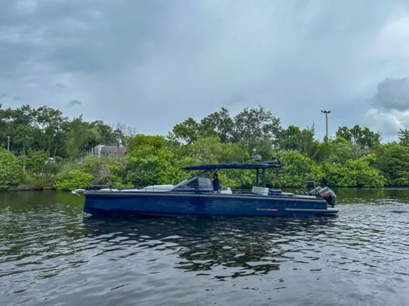 Slide: The Image of 2024 BRABUS Shadow 1000 ST boat on a calm river with lush greenery. - 7