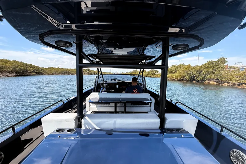 Slide: The Image of The image shows a modern boat with a sleek black roof and white seating on calm waters. - 24