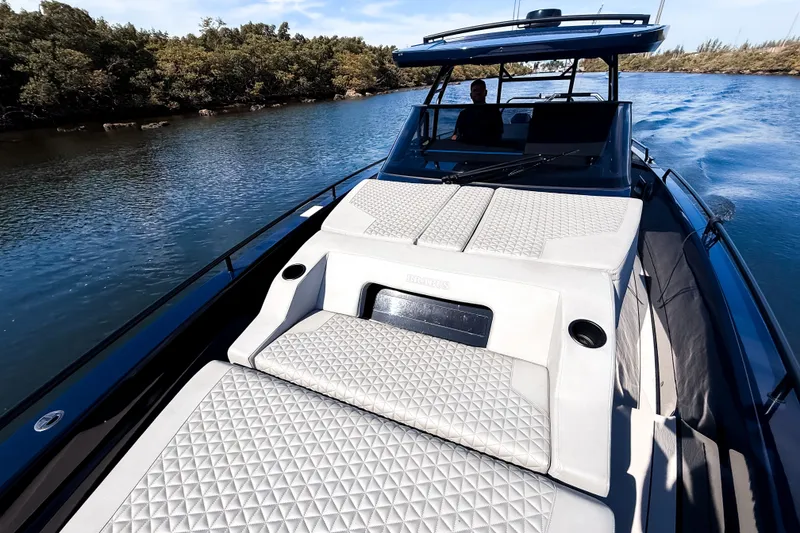 Slide: The Image of The image shows a luxury boat with cushioned sunbeds and a sleek design on a calm river. - 39