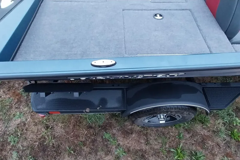 Slide: The Image of 2024 Ranger RT198P boat trailer with carpeted deck and wheel on grassy ground. - 19