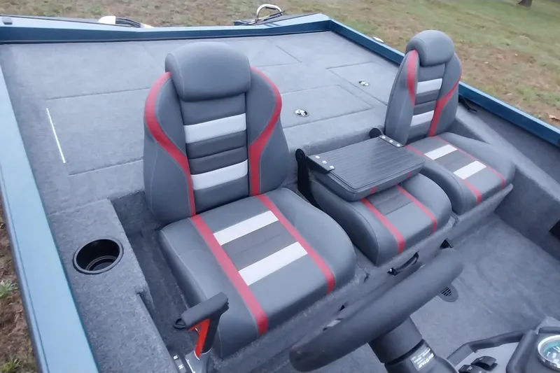 Slide: The Image of 2024 Ranger RT198P boat interior with gray and red seats, steering wheel, and cup holder. - 25