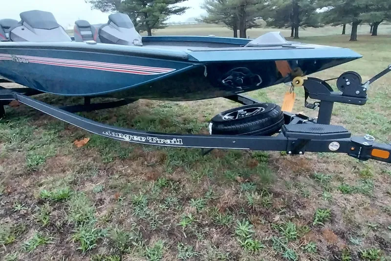 Slide: The Image of 2024 Ranger RT198P boat on trailer, parked on grassy area. - 33