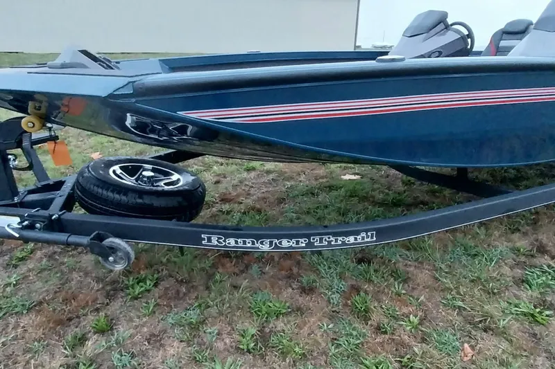 Slide: The Image of 2024 Ranger RT198P boat on trailer, side view, parked on grass. - 40