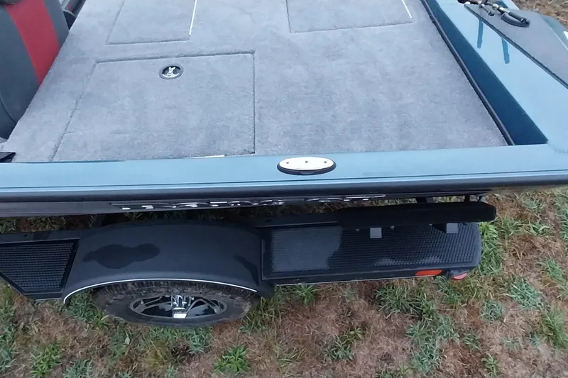 Slide: The Image of 2024 Ranger RT198P boat trailer with carpeted deck and wheel on grass. - 6