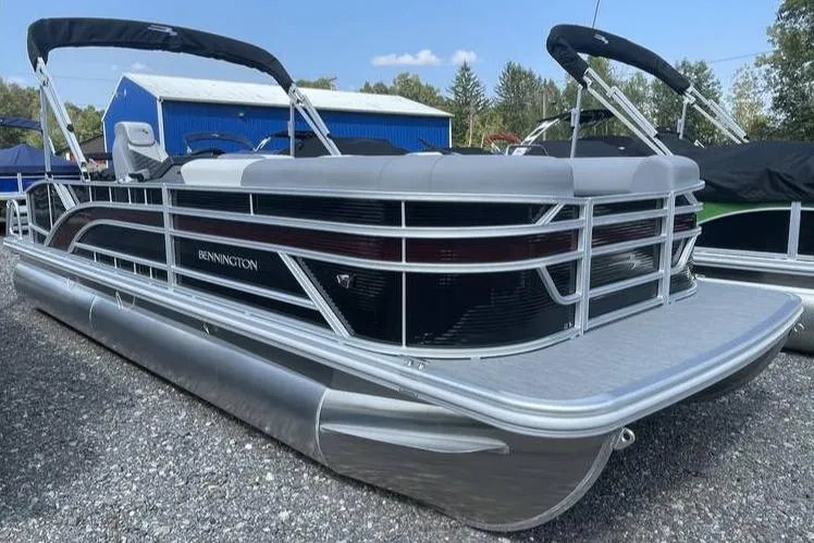 The Image of 2025 Bennington SLJSR pontoon boat with sleek design, docked outdoors. - 0