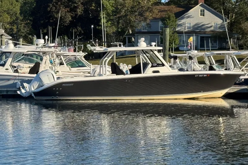 The Image of 2023 Pursuit S 328 Sport boat docked in a serene marina setting. - 0
