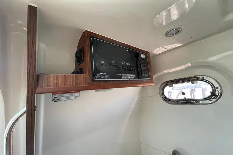 Slide: The Image of 2023 Pursuit S 328 Sport boat interior with control panel and porthole window. - 14