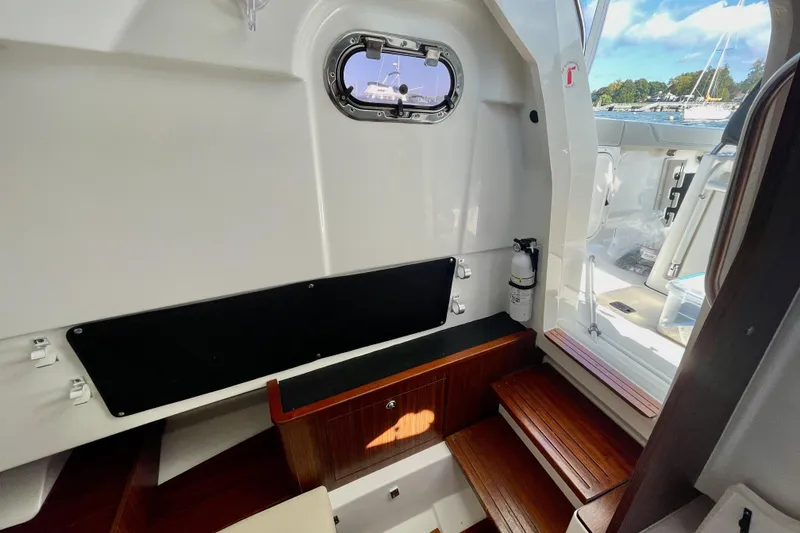 Slide: The Image of Interior of 2023 Pursuit S 328 Sport boat with wooden steps and porthole. - 15
