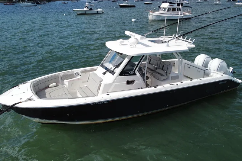 Slide: The Image of 2023 Pursuit S 328 Sport boat on water, featuring sleek design and spacious seating. - 2