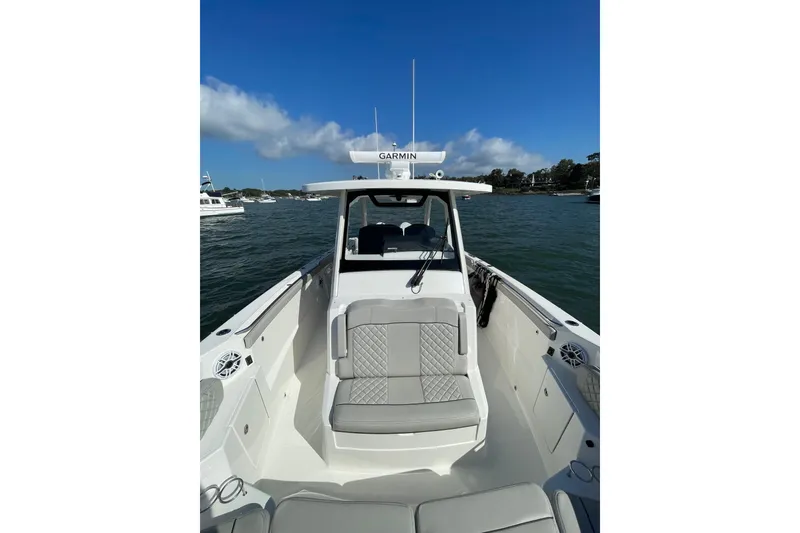 Slide: The Image of 2023 Pursuit S 328 Sport boat on water, featuring sleek seating and Garmin equipment. - 21