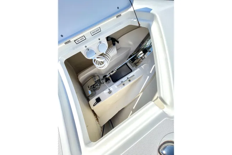 Slide: The Image of 2023 Pursuit S 328 Sport boat interior with water controls and storage compartment. - 23