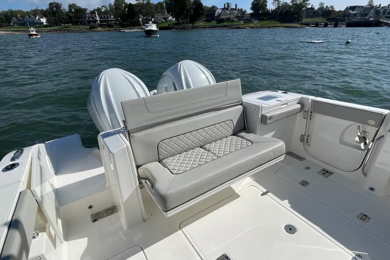 Slide: The Image of 2023 Pursuit S 328 Sport boat with luxurious seating and dual engines on a scenic lake. - 31