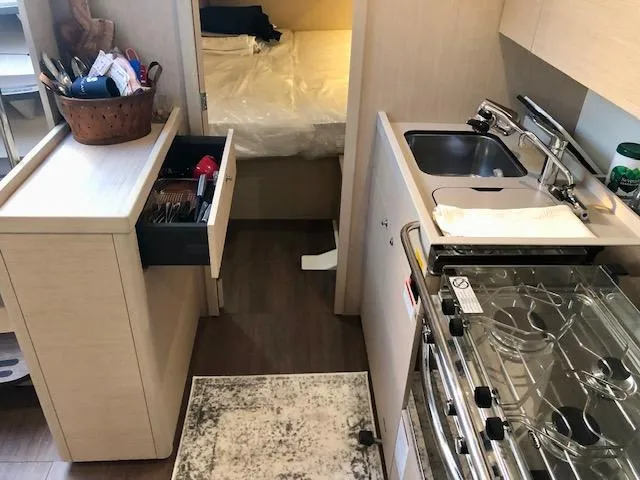 Slide: The Image of Modern kitchen interior of 2023 Beneteau Oceanis 46.1 yacht with stove, sink, and storage. - 28