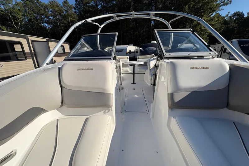 Slide: The Image of 2010 Sea-Doo 210 Challenger SE boat interior with seating and windshield, parked outdoors. - 13