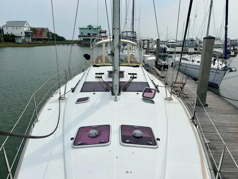 Slide: The Image of Jeanneau 50 DS 2012 sailboat docked at marina, showcasing deck and nearby waterfront homes. - 12