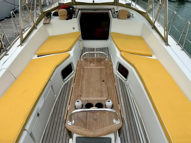Slide: The Image of Cockpit of 2012 Jeanneau 50 DS sailboat with yellow cushions and wooden table. - 17