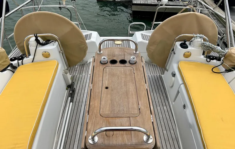 Slide: The Image of Cockpit of 2012 Jeanneau 50 DS sailboat with yellow cushions and wooden table. - 18