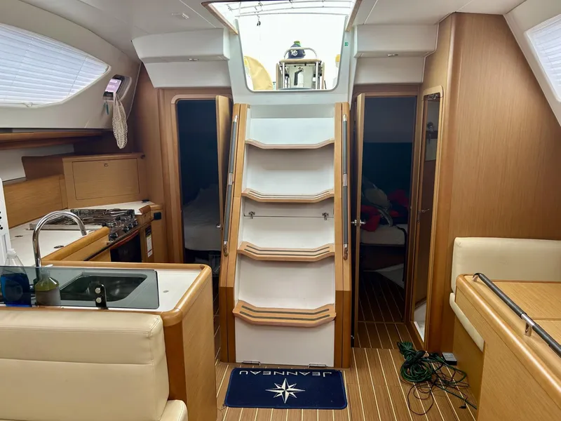 Slide: The Image of Interior of 2012 Jeanneau 50 DS yacht, featuring kitchen, stairs, and cozy cabin spaces. - 22