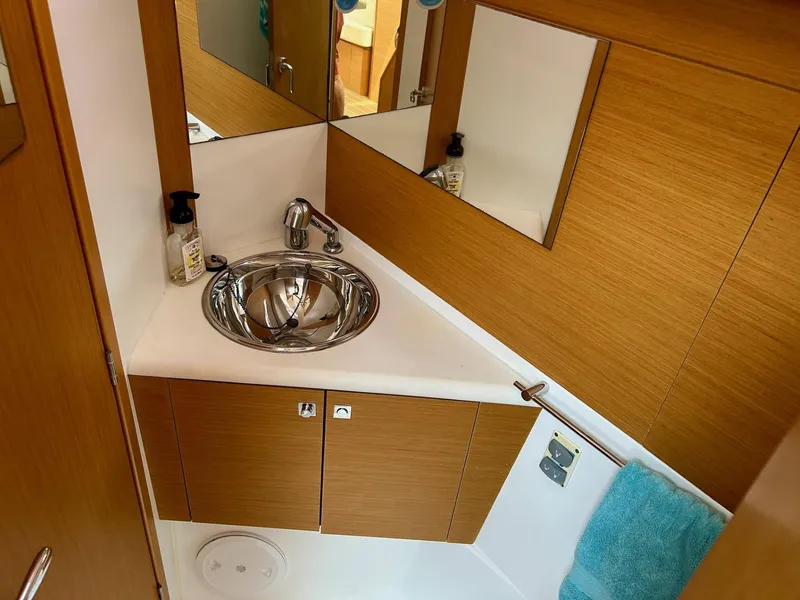 Slide: The Image of Compact bathroom in 2012 Jeanneau 50 DS yacht with modern sink and wooden cabinetry. - 28