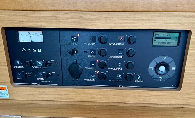 Slide: The Image of Control panel of a 2012 Jeanneau 50 DS sailboat, featuring various switches and gauges. - 29