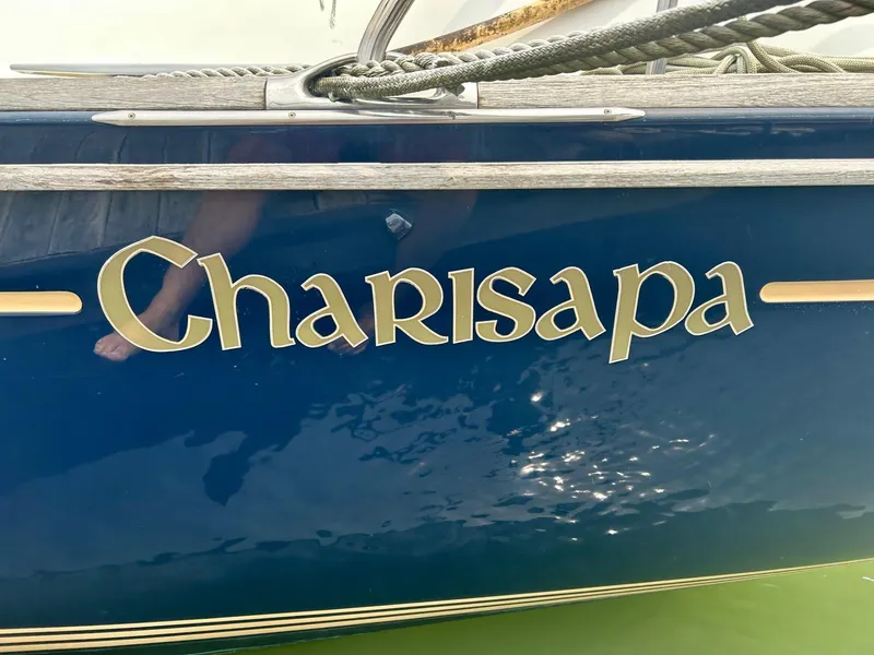 Slide: The Image of Jeanneau 50 DS 2012 sailboat named "Charisapa" with blue hull and gold lettering. - 6