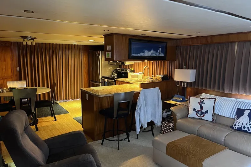 Slide: The Image of Luxurious interior of a 1997 Pluckebaum 60 Motor Yacht with modern kitchen and cozy seating area. - 12