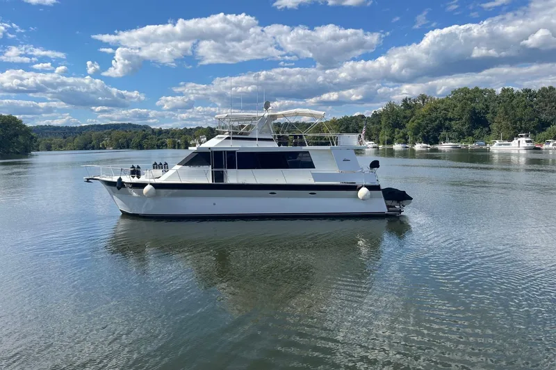 Slide: The Image of 1997 Pluckebaum 60 Motor Yacht on a serene lake under a blue sky. - 2