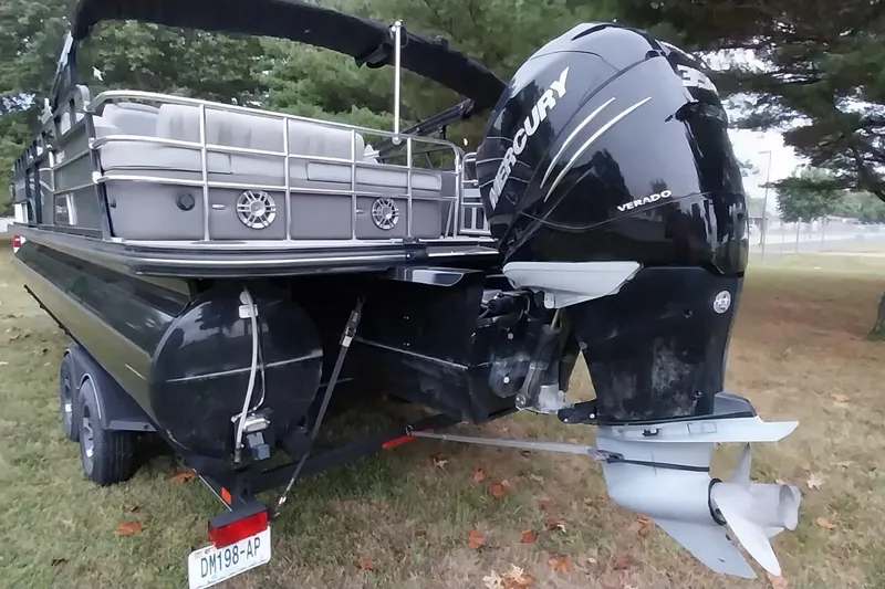 Slide: The Image of 2020 Ranger 2500LS pontoon boat with Mercury Verado engine on grassy area. - 2