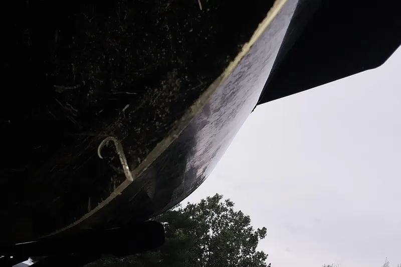 Slide: The Image of 2020 Ranger 2500LS boat hull close-up with sky and trees in background. - 21