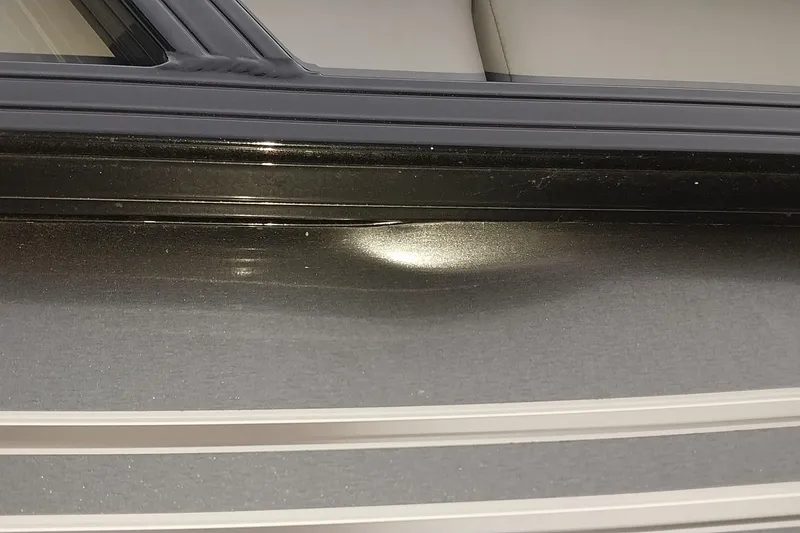 Slide: The Image of 2020 Ranger 2500LS boat with a dent on the black exterior surface. - 26