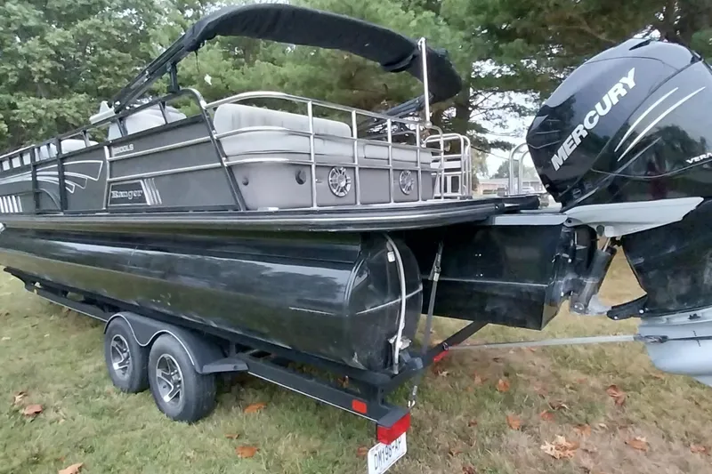 Slide: The Image of 2020 Ranger 2500LS pontoon boat with Mercury engine on a trailer, parked on grass. - 31