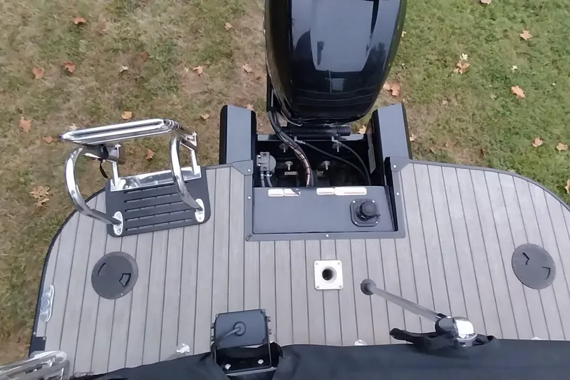 Slide: The Image of 2020 Ranger 2500LS boat deck with motor and ladder, on grassy background. - 45