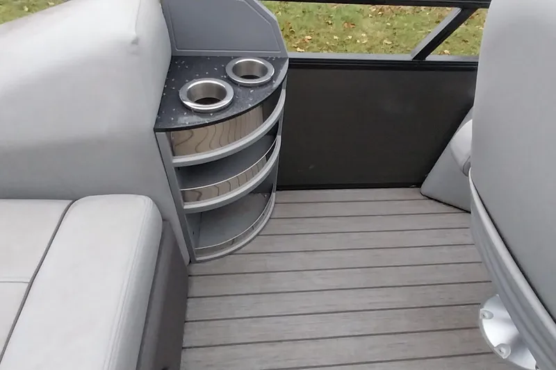 Slide: The Image of 2020 Ranger 2500LS boat interior with cup holders and seating on a wooden deck. - 51