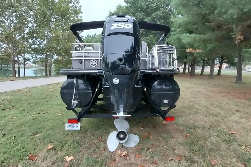 Slide: The Image of 2020 Ranger 2500LS boat with 350 horsepower engine, parked on grassy area near trees. - 82