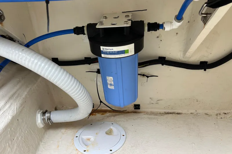 Slide: The Image of Open storage compartment on 2019 Aquila 44 boat, showing water tank and fittings. - 118