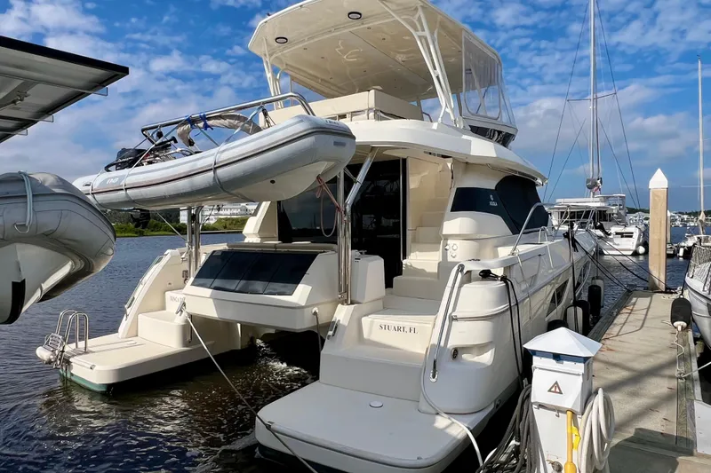 Slide: The Image of 2019 Aquila 44 yacht docked with inflatable boat, clear sky background. - 12
